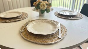 A dining table set with plates, cutlery, and a vase with flowers. - Charming 3-bedroom house  in delightful Katy! Perfect for family groups! (Katy)