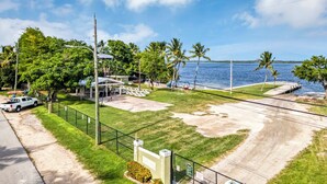 Una propiedad costera con un camino pavimentado, una zona vallada y vista al mar.