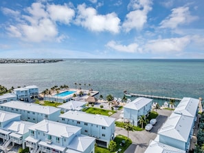 A coastal hotel with multiple buildings, a swimming pool, and a dock extending into the sea. - Modern, Oceanfront Views Apartment in Marathon with a pool and a marina (Marathon)