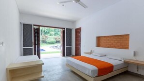 A modern bedroom with a bed, a wooden nightstand, a ceiling fan, and a view of the outdoors. - Yeguas W27 by Wynwood House (Anapoima)