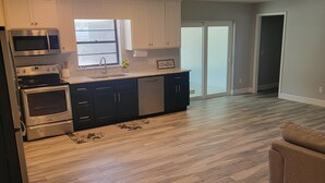 A modern kitchen with stainless steel appliances, a large window, and a wooden floor. - Fisherman's Paradise w/ Waterfront and 2 KING suites. Bring your boat! 40' dock (Homosassa)