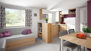 Une cuisine moderne avec des meubles en bois, une table à manger avec des chaises et une bibliothèque intégrée.