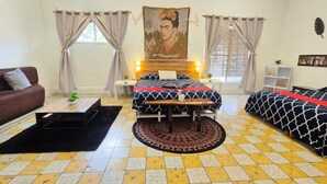 A room with a bed, a sofa, a small table, and a rug. - Economic Master double Queen-size-room in Downtown Mérida (Mérida)
