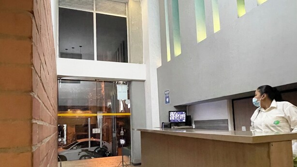 A reception area with a counter, a tiled floor, and a brick wall.