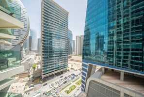 Uma área urbana moderna com edifícios altos, um estacionamento e um hotel chamado 'MERA'.