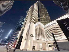 A modern building with a unique facade, large windows, and a prominent entrance.
