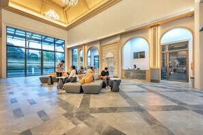 A spacious lobby with modern seating, large windows, and a reception area. - A.z.sunrise Resort And Fitness Club (Choeng Thale)