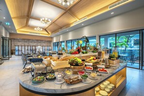 Un bar à petit-déjeuner moderne proposant une variété de plats et offrant une vue sur l’extérieur.