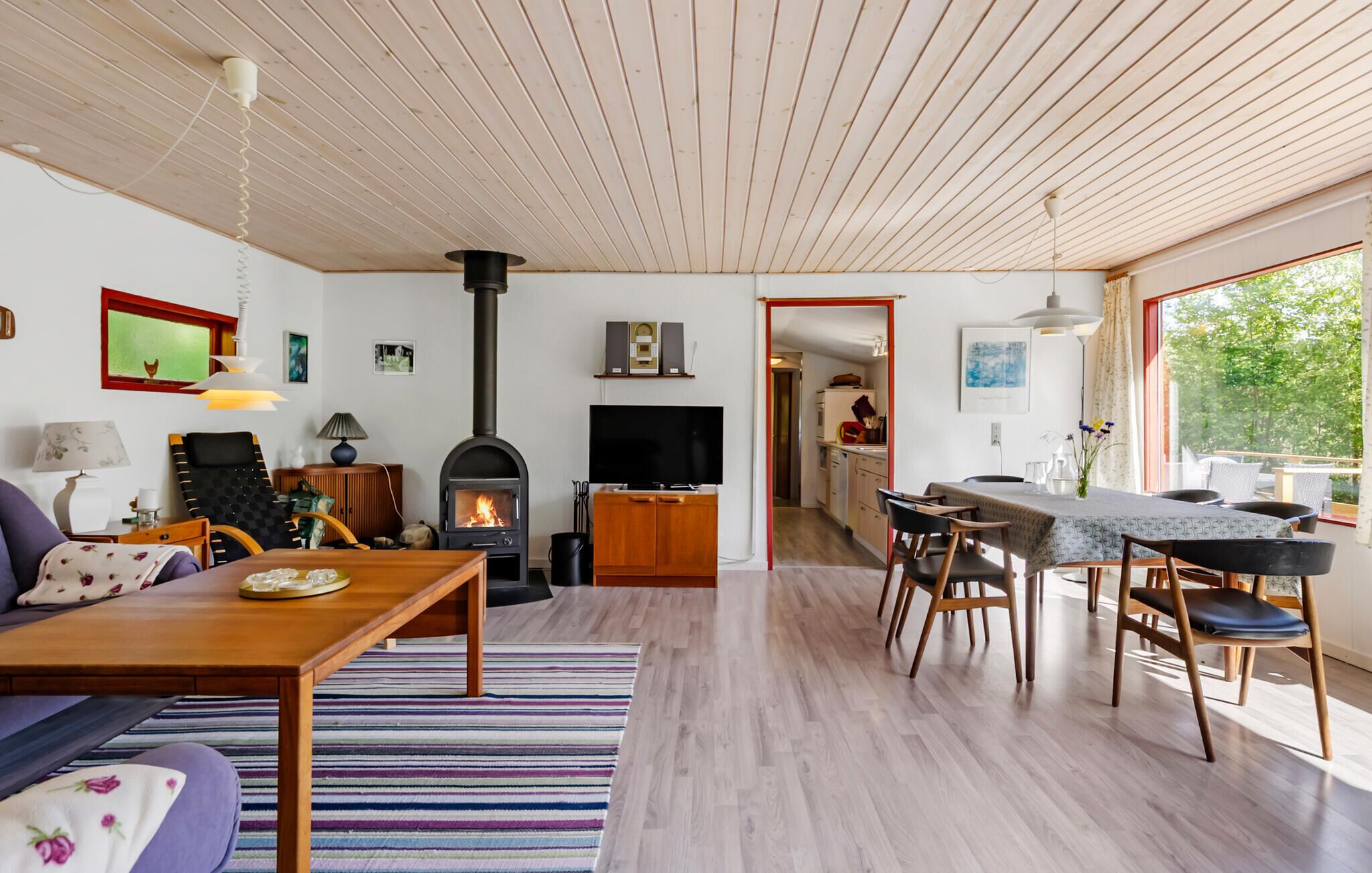 Un salón comedor amplio con chimenea, zona de comedor y cocina.