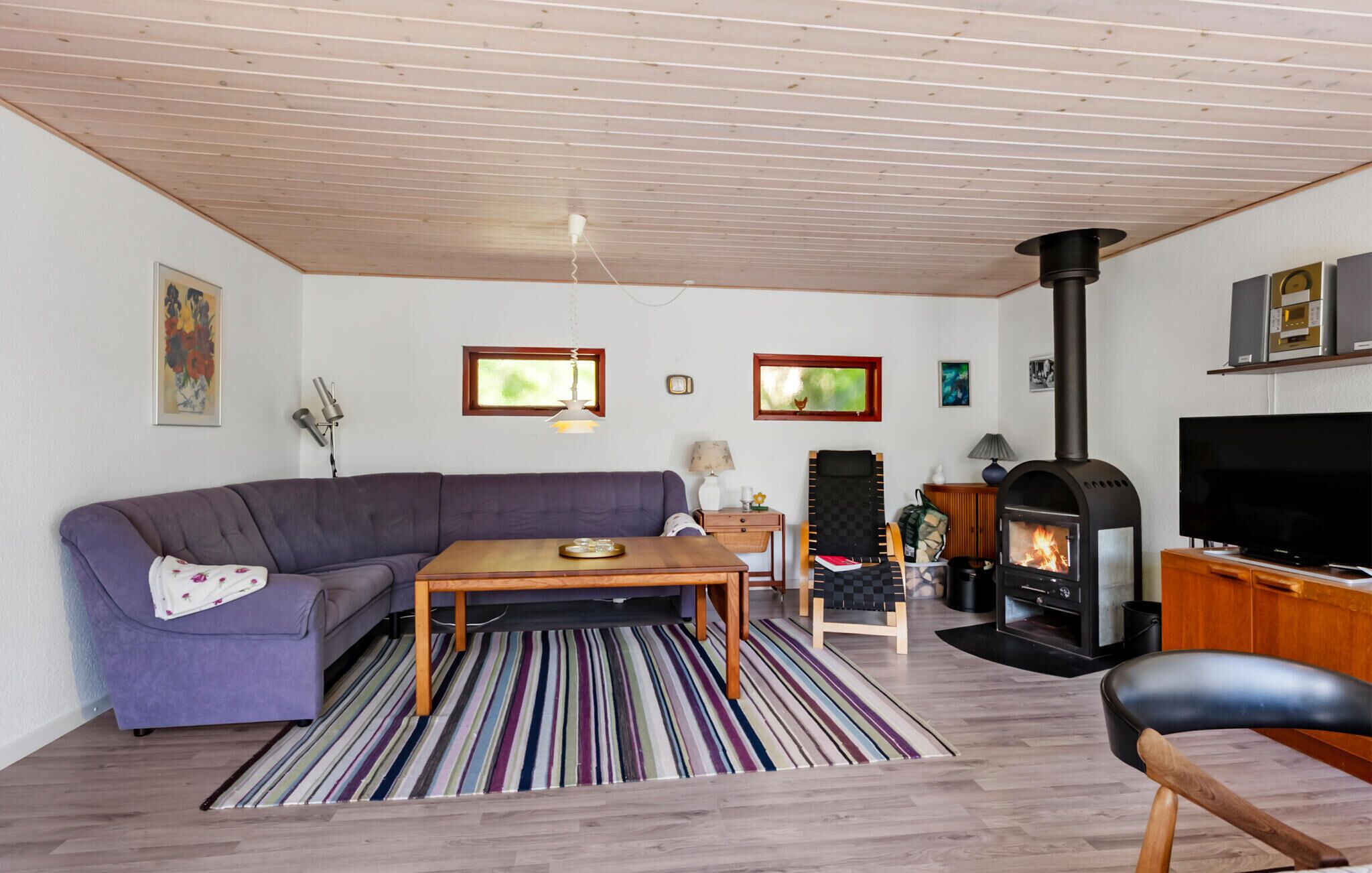 A living room with a sofa, a coffee table, a fireplace, and a television.