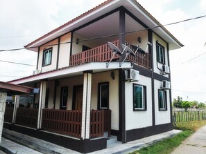 A two-story house with a balcony, a porch, and a fenced yard. - Haji Hassan Guest House (Langkawi)