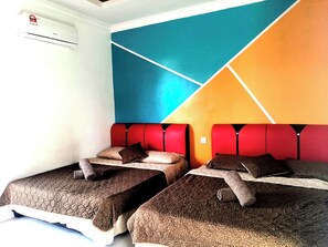Habitación con dos camas, cada una con cubrecama y almohadas de textura marrón, y cabecera roja.