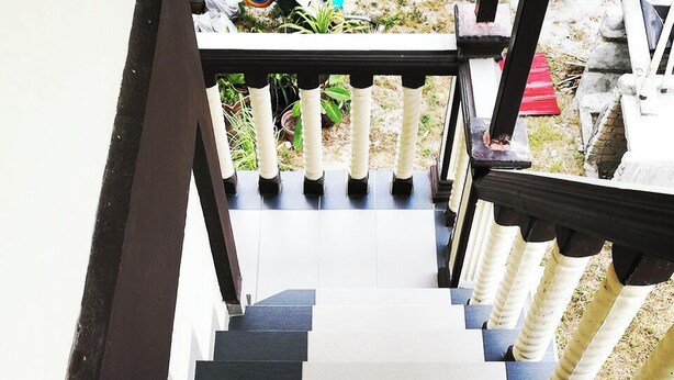 A staircase with alternating black and white steps, leading to a balcony with a railing. - Haji Hassan Guest House (Langkawi)