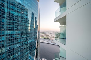 Um edifício alto com fachada de vidro, com vista para um rio e a paisagem urbana.