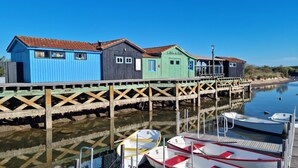 A wooden pier with colorful buildings and boats docked at the end. - Bel Appartement Proche Mer (Royan)