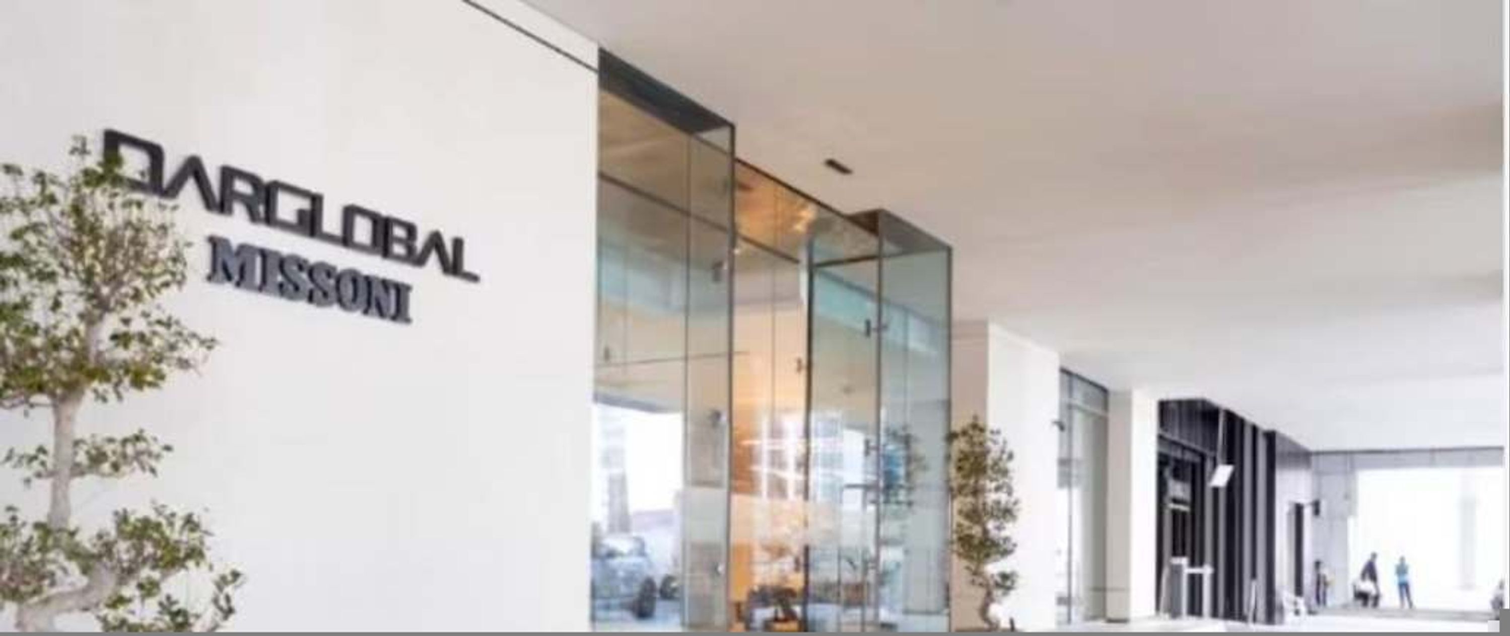 Un edificio moderno con fachada de vidrio y un letrero que dice 'DARGLOBAL MISSON'.