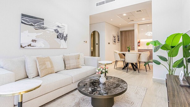 En moderne stue med sofa, sofabord og spiseplads.