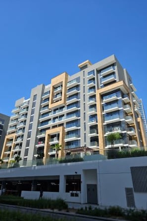 A multi-story residential building with balconies, a flat roof, and a modern architectural design. - Luxurious 1BR Living in Azizi Riviera 39 (Dubai)