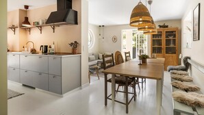 A modern kitchen with grey cabinets, a central island, and a dining area with a wooden table and chairs. - Lovely home in Tranekær with WiFi (Tranekær)