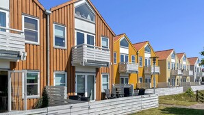 En række moderne boligbygninger med flere etager, altaner og store vinduer.