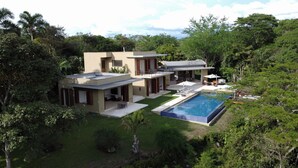 A modern two-story house with a swimming pool, surrounded by lush greenery. - Yeguas U31 by Wynwood House (Anapoima)
