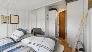 A bedroom with a bed, a chair, a door, and a radiator. - 2 bedroom amazing home in Martofte (Martofte)