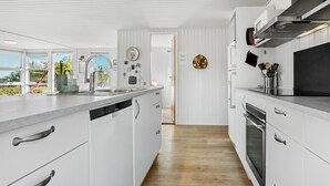 Eine moderne Küche mit weißen Schränken, Edelstahlgeräten und Holzboden.