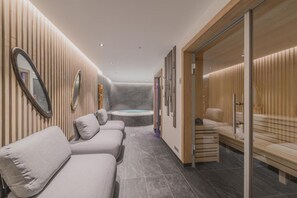 A modern spa area with a massage room, a relaxation area with benches, and a visible hot tub. - Residence Terresens Le Quartz (Peisey-Nancroix)