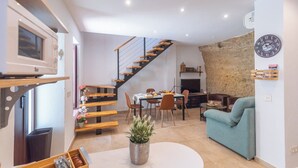 Una sala de estar moderna con una escalera, un comedor y una cocina.