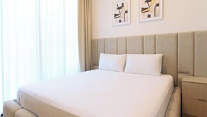 Uma cama grande com cabeceira, mesa de cabeceira e criado-mudo.