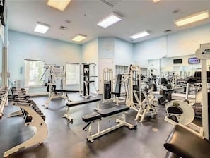 A gym with various exercise equipment, including dumbbells, benches, and weight machines.