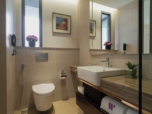 A modern bathroom with a shower, toilet, sink, and a mirror. - W Residence Living (Dhaka)