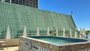 A pool area with a tiled border and a sign reading "Foster Tower." - Cozy studio in Waikiki  across the street from Waikiki Beach (Honolulu)