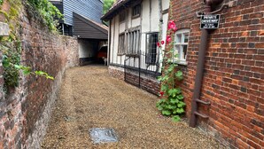 A private driveway with a brick wall, a metal gate, and a sign indicating no public right of way.