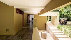 A modern building with a long corridor, a staircase, and a vehicle parked outside.