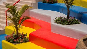 Eine Treppe mit bunten Stufen und kleinen Pflanzen an der Basis jeder Stufe.