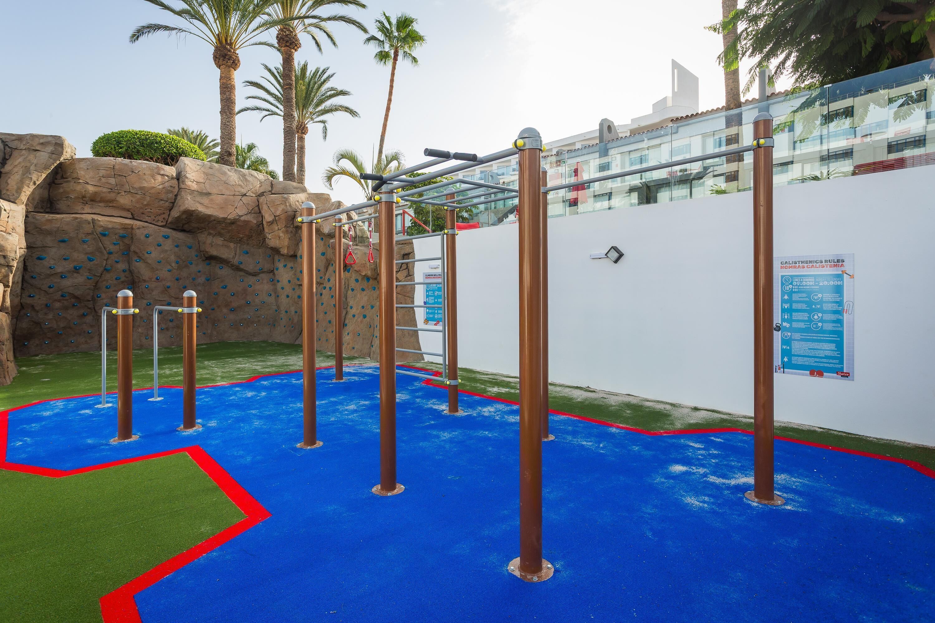 An outdoor play area with climbing structures and a rock wall.