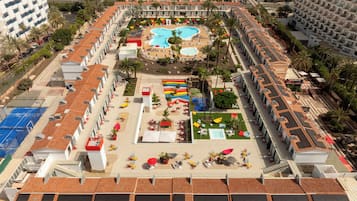 Eine Vogelperspektive eines Hotels mit mehreren Schwimmbecken, Sitzbereichen im Freien und vielfältigen Annehmlichkeiten.