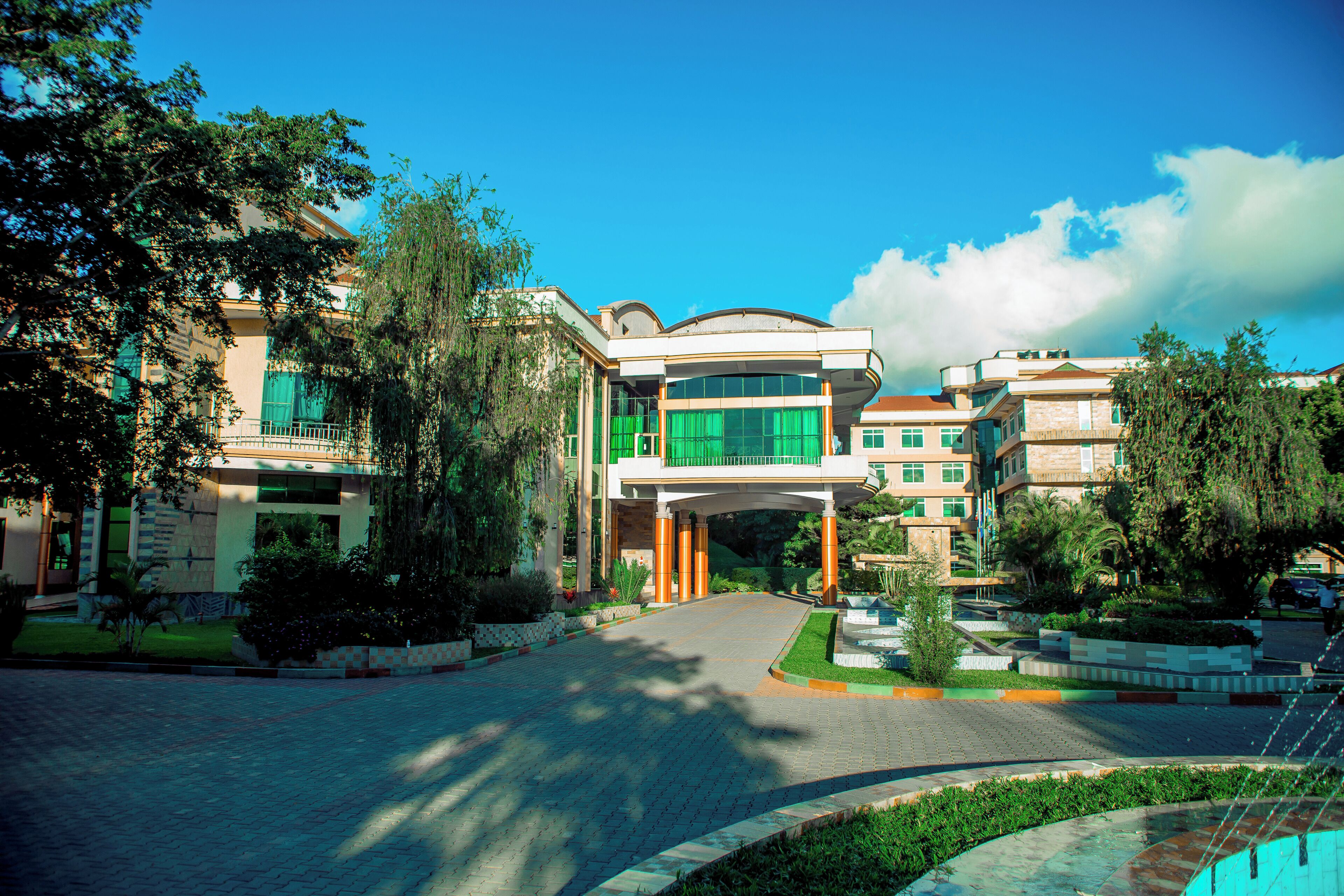 A multi-story hotel with a central courtyard, green shutters, and a fountain.