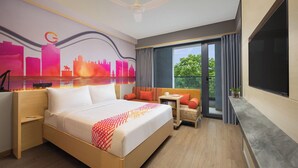 A hotel room with a bed, a small table, a TV, and a balcony with curtains. - Ginger Udaipur, Shastri Circle (Udaipur)