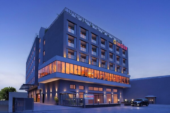 A modern hotel with a prominent "GINGER" sign, multiple balconies, and a well-lit facade. - Ginger Udaipur, Shastri Circle (Udaipur)