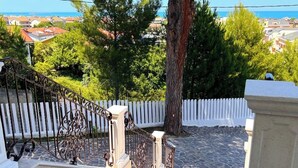 A wooden deck with a white picket fence, a metal railing, and a stone pathway leading to a white fence. - Villa near the sea (Francavilla Alla Mare)