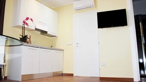 A modern kitchen with white cabinets, a built-in oven, and a flat-screen TV mounted on the wall. - Villa near the sea (Francavilla Alla Mare)