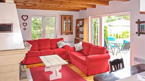 A cozy living room with a red sofa set, a white coffee table, and a wooden ceiling. - Beautiful home in Karsin with sauna (Karsin)