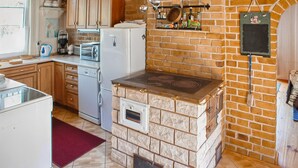 A compact kitchen with a built-in stove, a refrigerator, and a microwave. - Beautiful home in Karsin with sauna (Karsin)