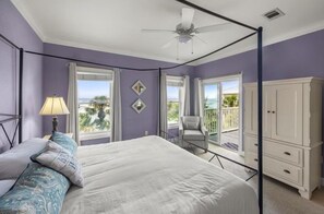 A bedroom with a bed, a chair, a wardrobe, and a balcony with a view. - Grouper Therapy (Santa Rosa Beach)