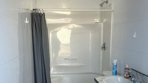 A compact bathroom with a bathtub, toilet, and sink. - Cabin 3 with AC and WiFi in charming Reed Point. ADA compliant. (Reed Point)