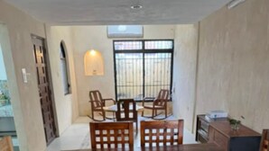 A dining area with a large wooden table, six chairs, and a patterned floor.