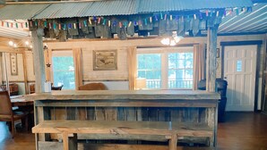 Eine rustikale Holztheke mit einer Bank, großen Fenstern und einer Decke mit dekorativen Blechdosen.