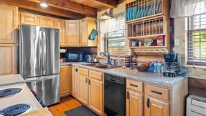 A kitchen with wooden cabinets, stainless steel appliances, a microwave, and a coffee maker.